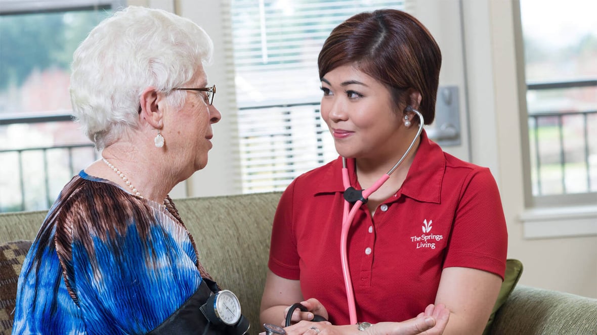 Caregiver taking vitals on resident