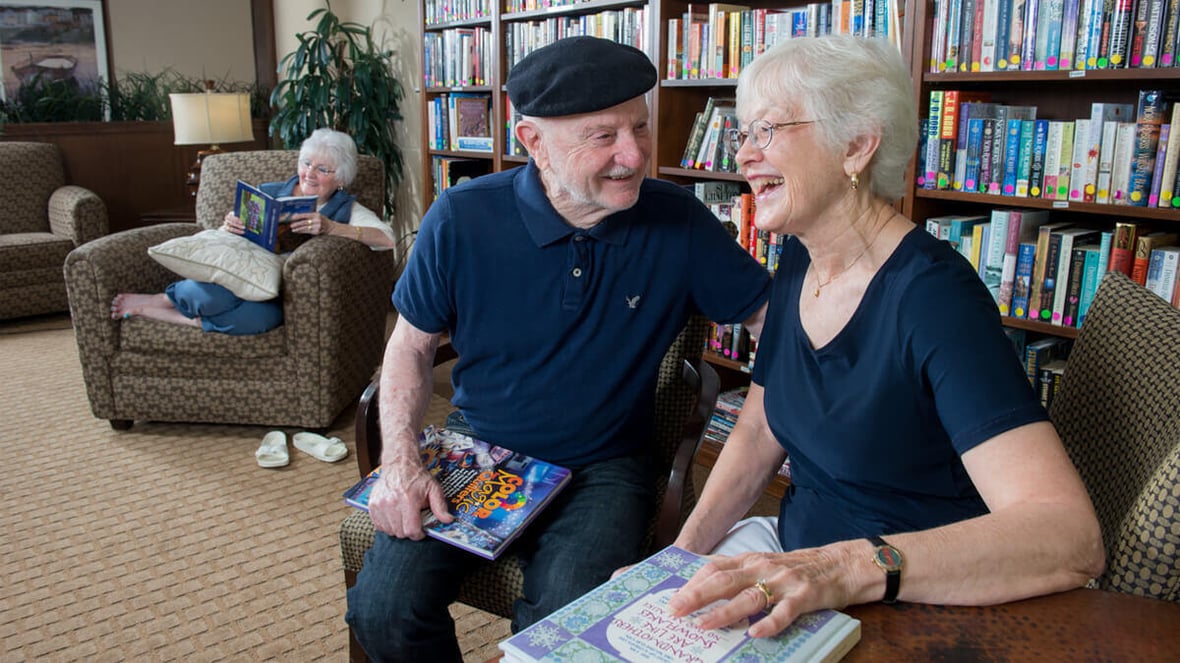 Residents enjoying reading time in the library at the Mill Creek community