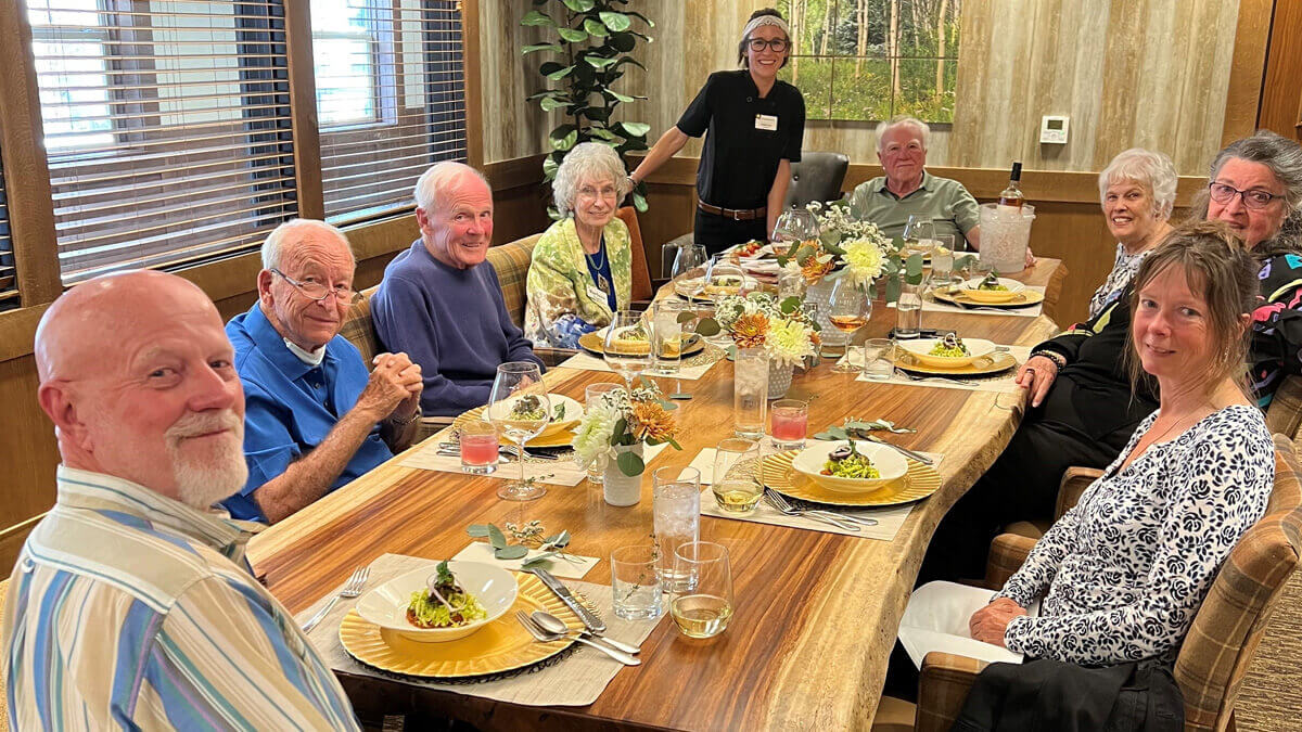 Residents dining at a large table at the Bozeman community