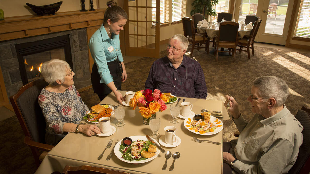Residents being served a meal in the fine dining restaurant