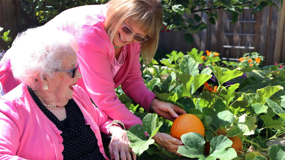 Two residents planting in the garden