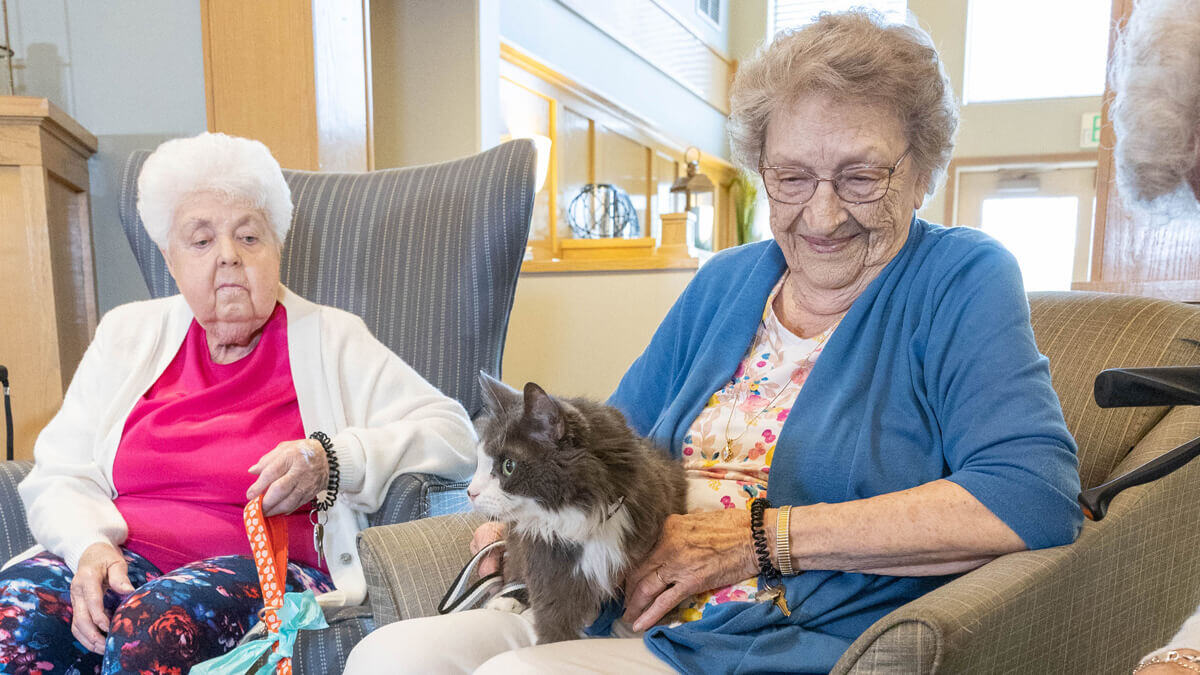 Two residents with a dog at the Sunnyview community