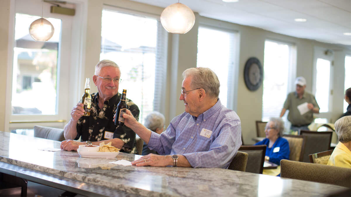 Two residents enjoying drinks and an appetizer at the bar at the Anna Maria community