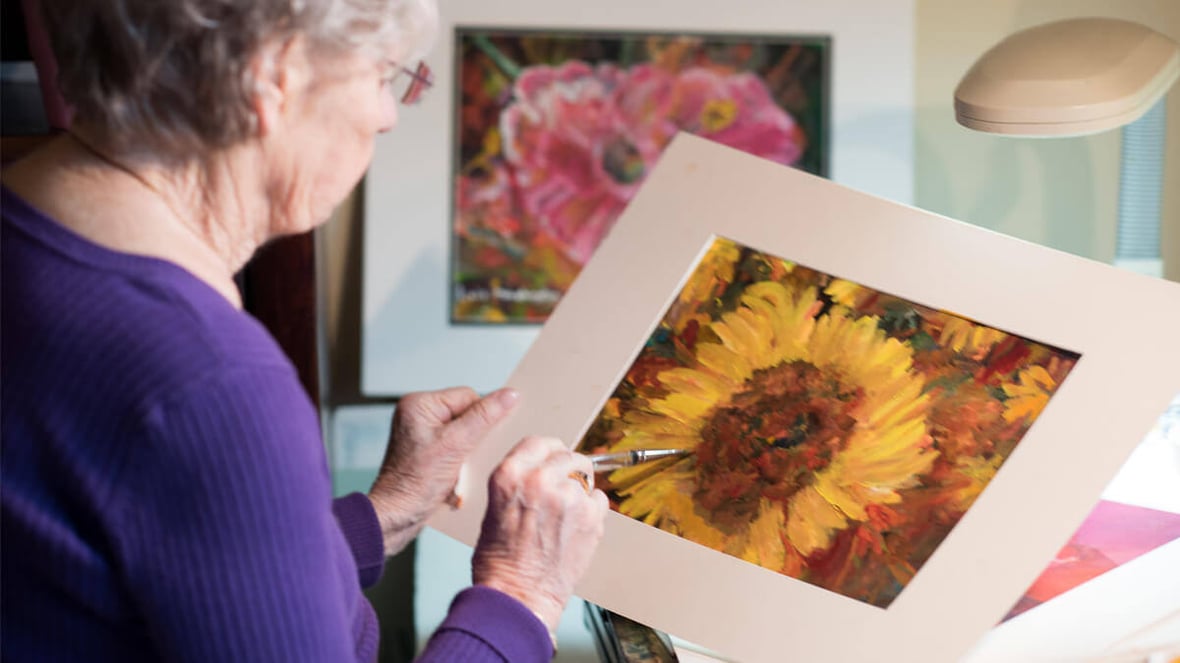 Woman completing artwork at Mill Creek community
