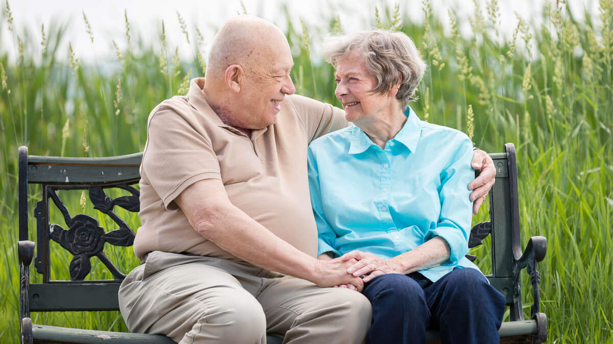 Resident couple sitting on a bench at the Whitefish community