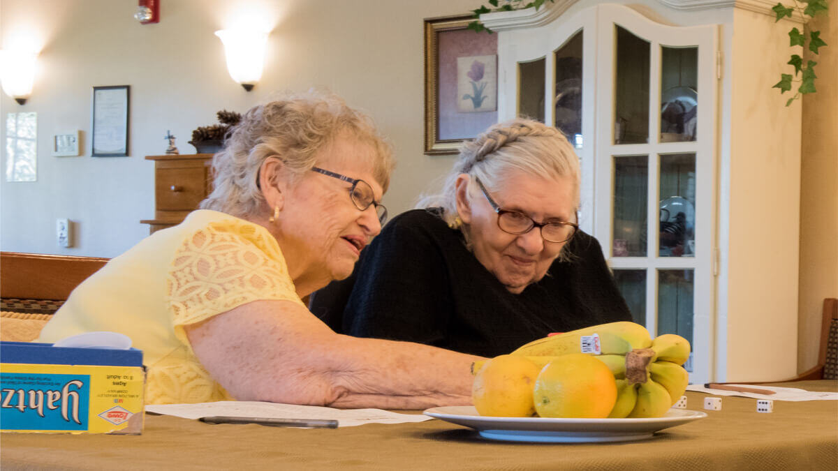 Two residents playing Yahtzee at the Willowcreek community