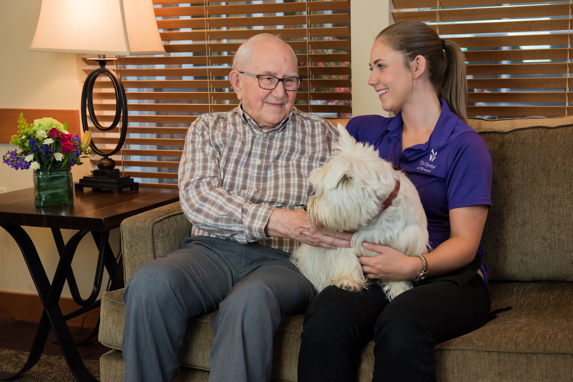 Two people and a dog sitting down