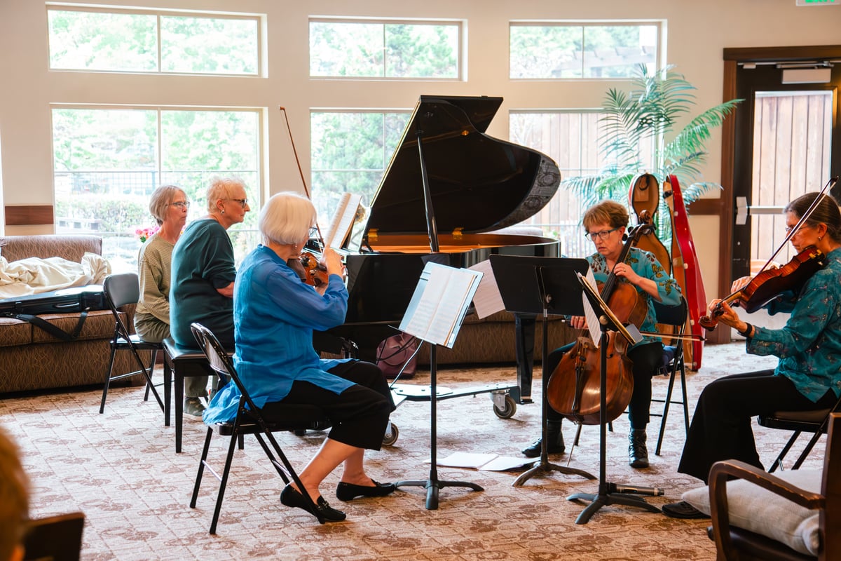 Older people gathered and playing music with classical instruments