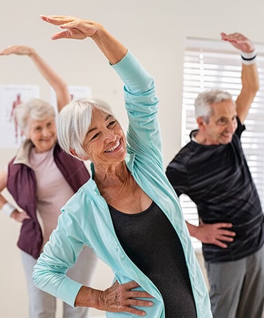 Senior people stretching at gym