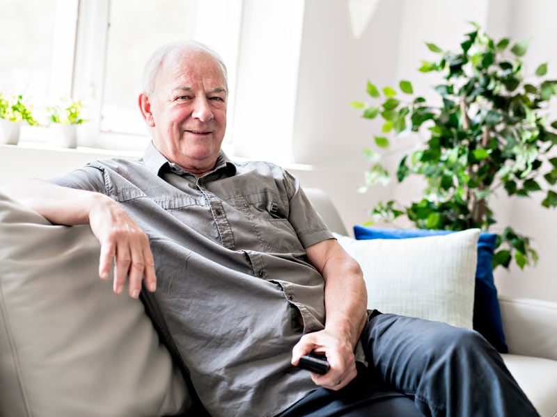 content man sitting on the couch with TV remote